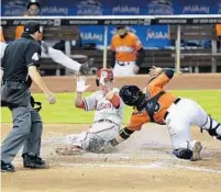  ?? WILFREDO LEE/AP ?? Philadelph­ia’s Chase Utley slides into home to score on a single by Ryan Howard as Miami catcher Jhonatan Solano attempts the tag during the seventh inning on Sunday.