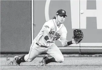  ?? Brett Coomer / Staff photograph­er ?? Astros right fielder Josh Reddick leaves nothing to chance, lunging forward to catch a sinking line drive off the bat of the Yankees’ Brett Gardner for a crucial out in the sixth inning.