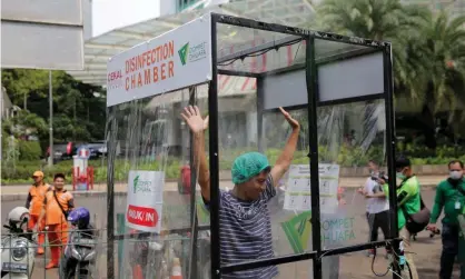  ?? Photograph: Barcroft Media/Barcroft Media via Getty Images ?? A woman is sprayed in a makeshift disinfecti­on chamber in Jakarta where there have been hundreds of cases of Covid-19.