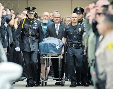  ?? Michael Owen Baker For The Times ?? WHITTIER POLICE Chief Jeff Piper, right, escorts the body of Officer Keith Boyer from UC Irvine Medical Center. Authoritie­s say Boyer was shot by an L.A. gang member who also is suspected of killing his own cousin.