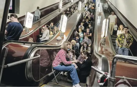  ?? EVGENIY MALOLETKA, AP ?? People take cover at a metro station during a Russian rocket attack in Kyiv, Ukraine, on Monday.