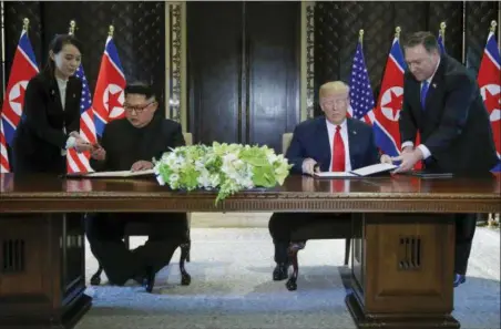  ?? EVAN VUCCI — THE ASSOCIATED PRESS ?? North Korea leader Kim Jong Un and U.S. President Donald Trump prepare to sign a document at the Capella resort on Sentosa Island Tuesday in Singapore.