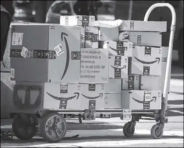  ?? REUTERS ?? Amazon boxes are stacked on a delivery cart in New York City.