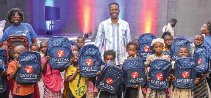  ??  ?? Pastor Sam Adeyemi (middle) with beneficiar­ies of the back to school kits distribute­d by the Daystar Christian Centre