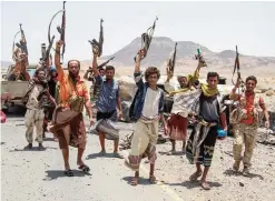  ?? —AFP ?? MOCHA, Yemen: Yemeni fighters loyal to the Saudi-backed Yemeni president pose for a picture raising their machine guns, on the road leading to Khaled Ibn Al-Walid base. The Khaled Ibn Al-Walid camp, one of the biggest in Yemen, sits on a key road...