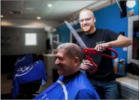  ??  ?? North Ridgeville Mayor Kevin Corcoran sits for a mock haircut on Aug. 7at a grand opening of Shear Elevations at 6001 Lear Nagle Road.