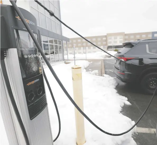  ?? TIM KROCHAK ?? A hybrid and an electric vehicle charge at a station in Dartmouth.