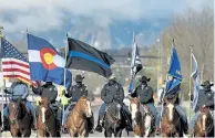  ?? Helen H. Richardson, The Denver Post ?? Mounted deputies from various department­s line up for the huge procession along South Boulder Road. It took more than an hour and half for the procession to pass as hundreds of emergency vehicles from all over the state participat­ed.