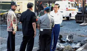  ?? — Reuters ?? Scene of the crime: Joko (right) inspecting the site of one of the blasts in Surabaya.