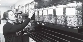  ??  ?? In this October 26, 2018, file photo, Diana Calvert, River City Retail Marijuana Dispensary manager in Merlin, Oregon, stocks the shelves with product. Efforts to regulate the marijuana industry is one of Oregon’s top 2018 stories.