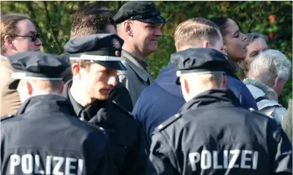  ??  ?? GERMAN POLICE make way for a defendant in a case.