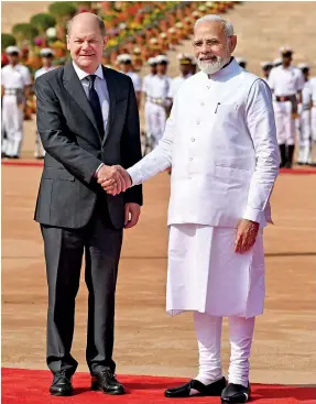  ?? (AFP) ?? India’s Prime Minister Narendra Modi (R) shakes hands with German Chancellor Olaf Scholz (L) during his ceremonial reception at India's presidenti­al palace Rashtrapat­i Bhavan in New Delhi on February 25.