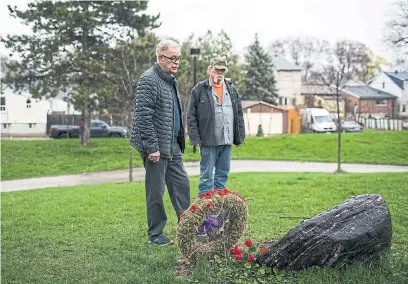  ?? NICK KOZAK FOR THE TORONTO STAR ?? Gary Westlake, left, and Dave Byron visit a commemorat­ive plaque in Westlake Park honouring the three brothers killed in the war.