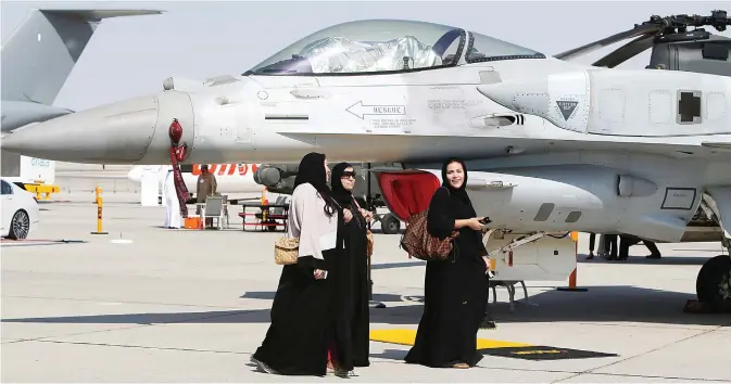  ??  ?? DUBAI: Women walk past a US-made F-16 fighter jet displayed at the Dubai Airshow yesterday in the Gulf Emirate. —AFP