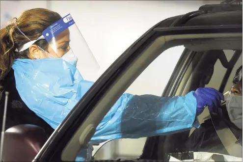  ?? Ned Gerard / Hearst Connecticu­t Media ?? Medical personnel work at a Hartford HealthCare drive-thru COVID-19 testing site in Bridgeport on Jan. 25.