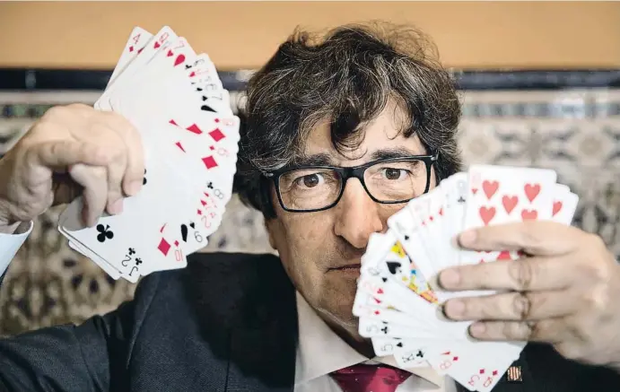  ?? HNA JIMÉNEZ ?? David Pérez bromea con dos juegos de cartas, después de mostrar algunos de sus trucos de magia, ayer, en el bar La Plata, en Barcelona, del que es asiduo