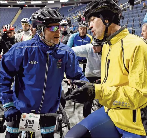  ??  ?? L’animateur et comédien Jean-Marie Lapointe discute avec l’ex-hockeyeur Joé Juneau un peu avant le départ des cyclistes hier matin au Centre Vidéotron.