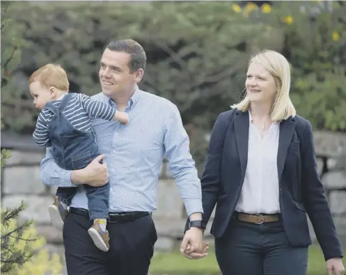  ??  ?? 0 Douglas Ross MP, new leader of the Scottish Conservati­ve s, with his wife Krystal and son Alistair at their home in Forres yesterday