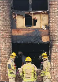  ?? (NWA Democrat-Gazette/Mary Jordan) ?? Springdale firefighte­rs examine the scene of an apartment fire Saturday at Colony Square Apartments.