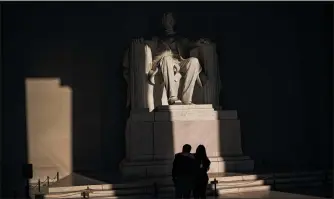  ?? HISTORY SALWAN GEORGES — THE WASHINGTON POST ?? A couple takes in the statue of Abraham Lincoln as the morning light starts to shine on May 18.