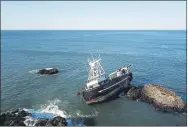  ?? CALIFORNIA DEPARTMENT OF FISH AND WILDLIFE PHOTO ?? The 90-foot vessel American Challenger is caught on rocks near Dillon Beach. Authoritie­s continue to investigat­e the risk of pollution and environmen­tal damage linked to the ship that crashed onto the shoreline.