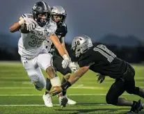  ??  ?? Demons running back Martell Mora breaks a tackle by the Jaguars’ Julian Muñoz. Mora ran for 261 yards and scored five touchdowns. Santa Fe High swept Capital and St. Michael’s, its two city rivals, for the first time in 13 years.