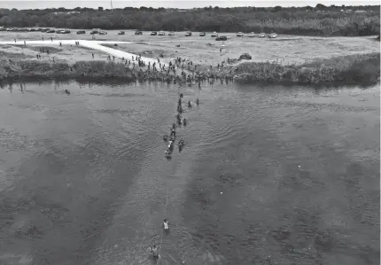  ?? FERNANDO LLANO/AP ?? Migrants, many from Haiti, wade across the Rio Grande from Del Rio, Texas, to return to Ciudad Acuna, Mexico, on Tuesday.