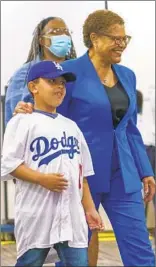  ?? DAMIAN DOVARGANES AP ?? Rep. Karen Bass smiles after casting her vote Tuesday with her stepdaught­er and grandson.