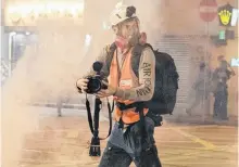  ?? REUTERS ?? Norwegian filmmaker Anders Hammer, director of the “Do Not Split” documentar­y, films a protest while wearing a gas mask in Hong Kong, China, in this 2019 handout photo courtesy of Oliver Haynes.