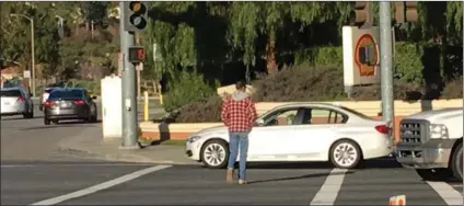  ?? Photo courtesy of Santa Clarita Valley Sheriff’s Station ?? In this file photo, a vehicle illegally crosses in the path of an undercover Santa Clarita Valley Sheriff’s Station deputy crossing the street. Law enforcemen­t officials carried out more safety sting operations on Wednesday aimed at making motorists...