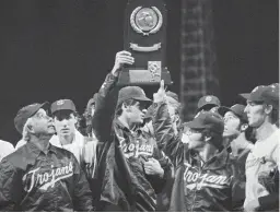  ?? AP ?? Southern California coach Rod Dedeaux, left, proudly looks at the College World Series trophy the Trojans won in Omaha, Neb., in 1974.