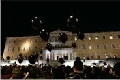  ?? YORGOS KARAHALIS — THE ASSOCIATED PRESS ?? Demonstrat­ors hold black balloons during a silent protest in front of the parliament in Athens on Friday.