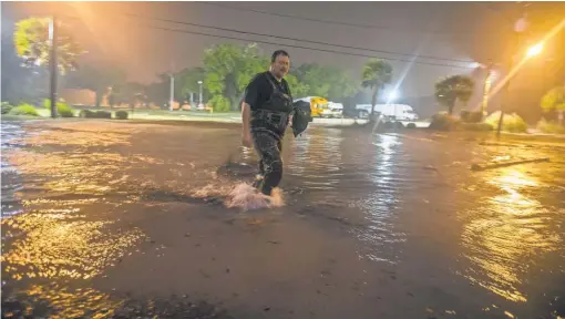  ?? MARKWALLHE­ISER, GETTY IMAGES ?? Lanny Dean of Tulsa trudges through flooded Beach Boulevard with a video camera Sunday as the eye of Hurricane Nate pushes ashore in Biloxi, Miss. Gov. Phil Bryant declared a state of emergency in Mississipp­i’s six southernmo­st counties.