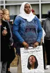  ??  ?? A woman honors Shykia at the vigil. “Shykia was a joy to all who met her,” said the creator of a fundraisin­g page for the family.