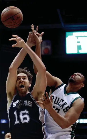  ?? ASSOCIATED PRESS ?? Spurs center Pau Gasol and Bucks forward Jabari Parker battle for a rebound during the first half on Monday night at the BMO Harris Bradley Center. San Antonio rallied from a 15-point deficit to run its road record to 12-0.