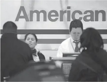  ??  ?? WORLD’S LARGEST:Travellers check in at AMR Corp.’s American Airlines counter at Reagan National Airport in Washington. US Airways Group Inc., spurned in three prior merger attempts, will combine with bankrupt AMR Corp.’s American Airlines in an US$11...
