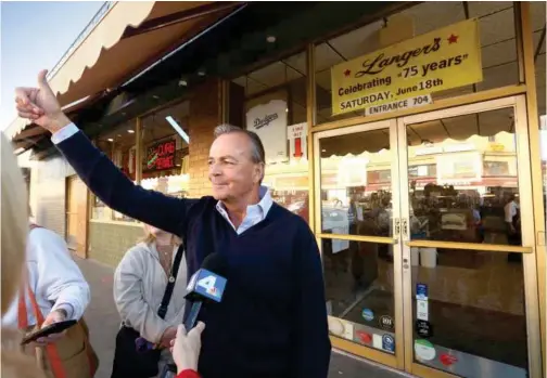  ?? ?? Rick Caruso gives a thumbs up as a van of supporters shouted their approval on passing while making a post election stop at Langer’s Deli in Macarthur Park in Los Angeles.