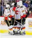  ?? Jack Dempsey/ The Associated Press ?? Teammates congratula­te Michael Ferland after he scored in the Flames’ 2- 1 win over the Avs.