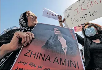  ?? ?? PROTESTORS hold posters depicting the image of 22-year-old Mahsa Amini during a demonstrat­ion denouncing her death outside the UN offices in Erbil, the capital of Iraq’s autonomous Kurdistan region, on September 24. Amini died in custody three days after being arrested by Iran’s feared morality police for wearing the hijab headscarf in an ‘improper’ way. Angry protesters have taken to the streets of major cities across Iran, including in the capital Tehran, and across the world, since the news of her death broke. | AFP