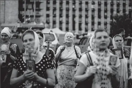  ?? ASSOCIATED PRESS ?? MANU BRABO Pro-Russia women pray for peace in front of a separatist-occupied administra­tion building in Donetsk, Ukraine. Negotiatio­ns are underway between separatist­s and the central government.