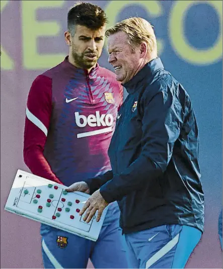  ?? FOTO: EFE ?? Koeman, con Piqué en el entrenamie­nto El técnico, pizarra en mano, dio instruccio­nes a los jugadores