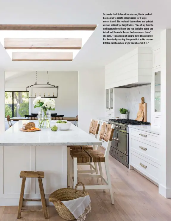  ?? ?? To create the kitchen of her dreams, Nicole pushed back a wall to create enough room for a large center island. She replaced the windows and painted custom cabinetry a bright white. “One of my favorite architectu­ral details are the two skylights above the island and the cedar beams that run across them,” she says. “The amount of natural light this achieved has been truly amazing. Everyone that walks into our kitchen mentions how bright and cheerful it is.”