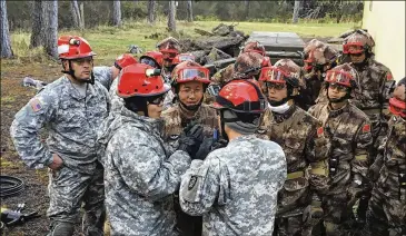  ??  ?? Soldiers from the U.S. Army and China’s People’s Liberation Army carry out a joint rescue response to a natural disaster in an exercise at Camp Rilea Armed Forces Training Center near Warrenton, Ore., on Nov. 18.