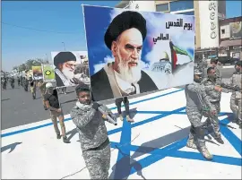  ?? HADI MIZBAN — THE ASSOCIATED PRESS ?? In this 2017 photo, supporters of Iraqi Hezbollah brigades march on a representa­tion of an Israeli flag with a portrait of late Iranian leader Ayatollah Khomeini and Iran’s supreme leader Ayatollah Ali Khamenei, in Baghdad, Iraq.