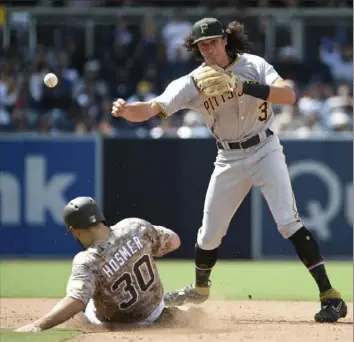  ?? Denis Poroy/Getty Images ?? Pirates shortstop Cole Tucker turns a double play over San Diego’s Eric Hosmer in the sixth inning Sunday at Petco Park.