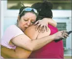  ??  ?? Carrie Matula embraces a woman after the fatal shooting that saw 26 killed and at least 16 hurt.