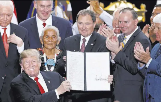  ?? Rick Bowmer The Associated Press ?? President Donald Trump on Dec. 4 in Salt Lake City holds a proclamati­on to shrink Bears Ears and Grand Staircase Escalante national monuments. Management plans for the monuments were issued last week.