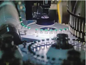  ?? DHIRAJ SINGH/ BLOOMBERG ?? Vials of Covishield, the local name for the COVID-19 vaccine developed by AstraZenec­a and the University of Oxford, move along a conveyor on the production line at the Serum Institute of India Ltd. Hadaspar plant in Pune, Maharashtr­a, India, on Jan. 22.