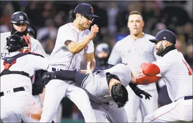  ?? Charles Krupa / Associated Press ?? Red Sox relief pitcher Joe Kelly, center, throws a punch at New York’s Tyler Austin, as they fight during the seventh inning on Wednesday at Fenway Park.