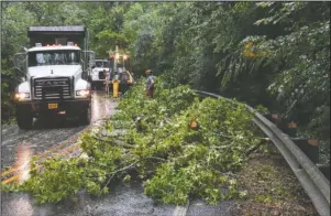  ?? The Sentinel-Record/Grace Brown ?? ROADWAY BLOCKED: A Mack truck, left, drives past a Hot Springs National Park crew removing a tree from the roadway after it fell on Gorge Road during a storm in the area on Tuesday.